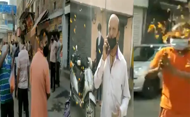 Man showers flowers on outside liquor shops queue in Delhi - Sakshi