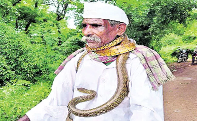 Karnataka Man With Snake Around His Neck On Cycle Goes Viral - Sakshi