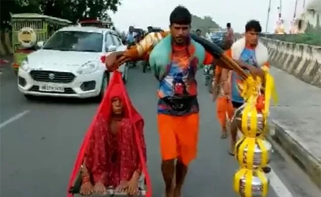 Viral Video: Man Carries Mother On Shoulder In Haridwar - Sakshi